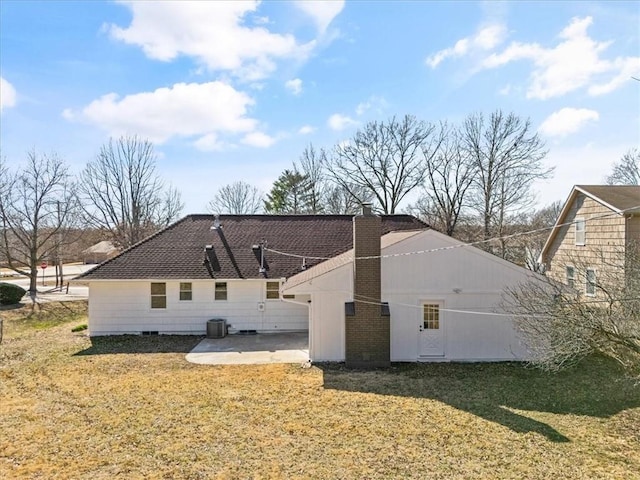 rear view of property with a patio area, central air condition unit, a chimney, and a yard