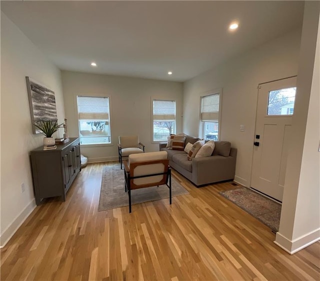 living area with baseboards, recessed lighting, and light wood-style floors