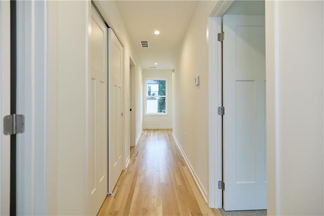 hall with light wood finished floors, recessed lighting, visible vents, and baseboards