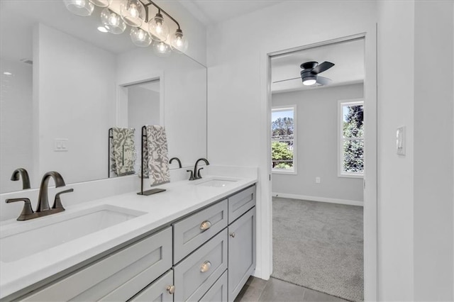 bathroom featuring tile patterned floors, a sink, baseboards, and double vanity