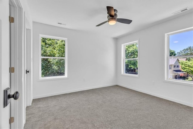 unfurnished room featuring carpet floors, a ceiling fan, visible vents, and baseboards