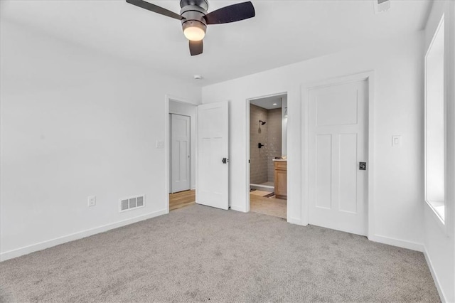 unfurnished bedroom featuring carpet floors, visible vents, a ceiling fan, ensuite bath, and baseboards