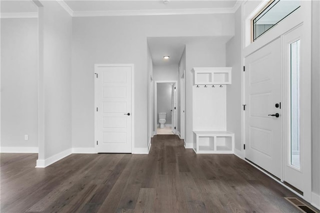 mudroom with ornamental molding, dark wood finished floors, visible vents, and baseboards