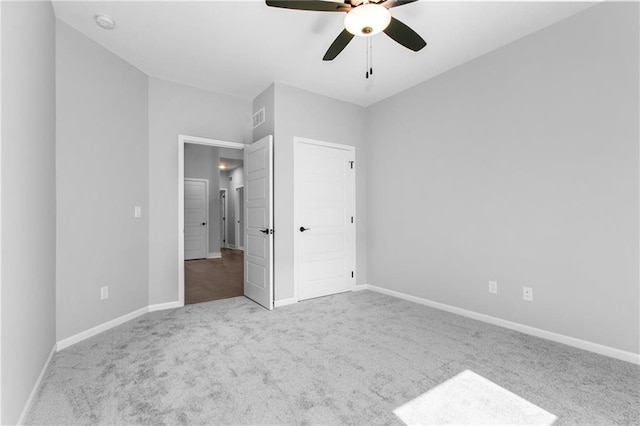 unfurnished bedroom featuring carpet, visible vents, ceiling fan, and baseboards