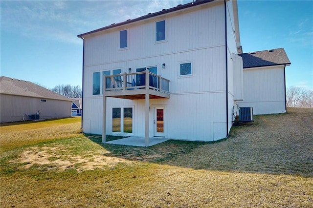 rear view of property with a patio area, central air condition unit, and a lawn