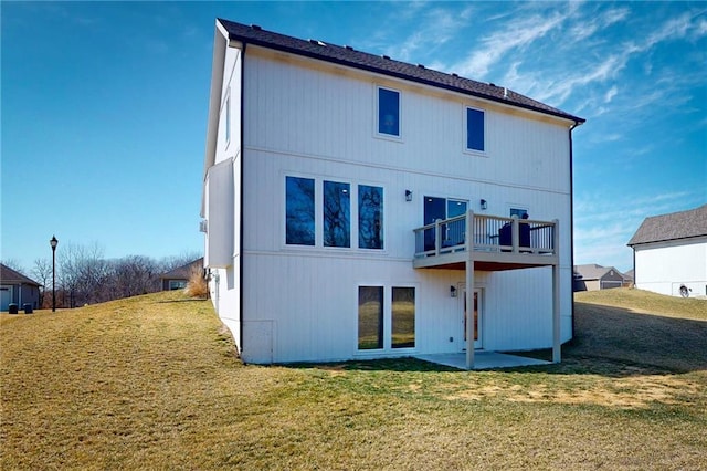 back of property with a balcony, a yard, and a patio area