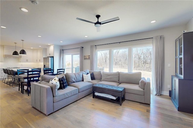 living room with recessed lighting, baseboards, ceiling fan, and light wood finished floors