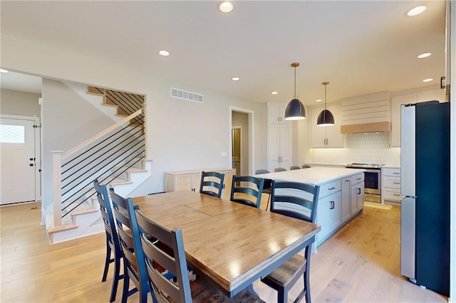 dining room featuring recessed lighting, visible vents, stairs, and light wood finished floors