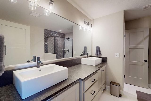 bathroom with double vanity, visible vents, a stall shower, and a sink