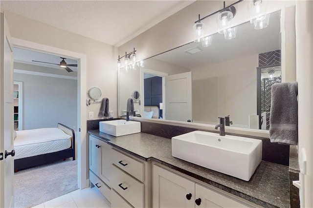 ensuite bathroom featuring double vanity, connected bathroom, ceiling fan, and a sink