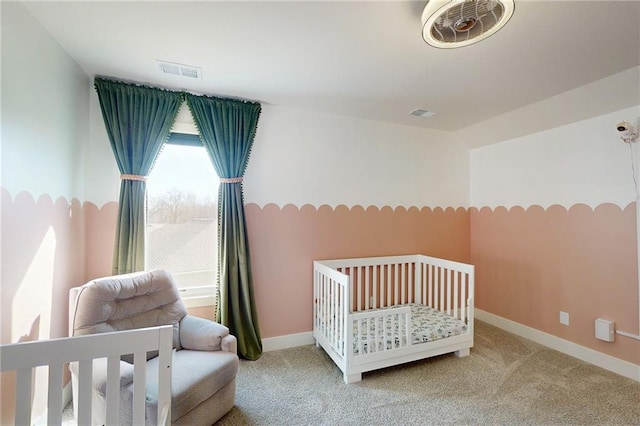 carpeted bedroom with a nursery area, baseboards, and visible vents