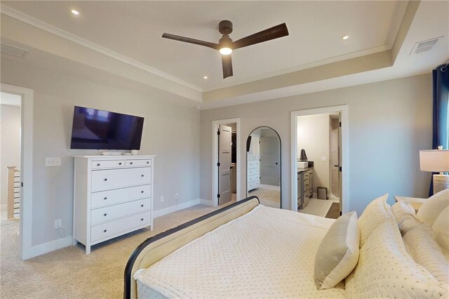 bedroom featuring light carpet, a walk in closet, baseboards, and ornamental molding