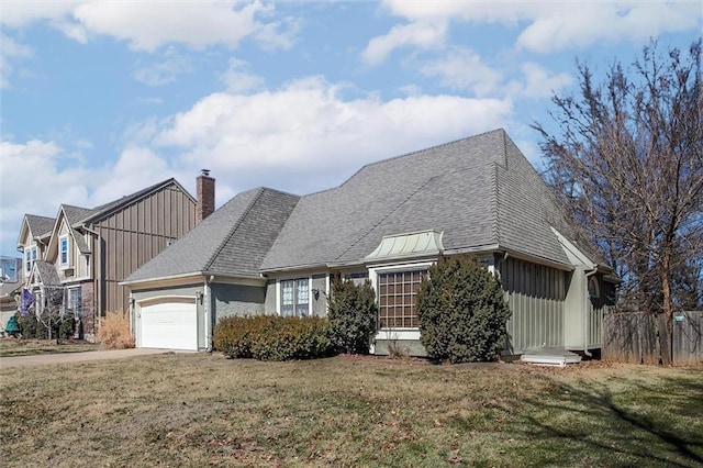 view of front of property featuring a garage, driveway, a front yard, and fence