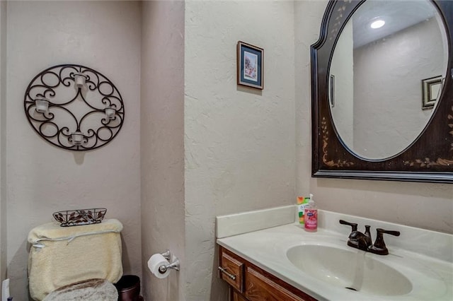 bathroom with vanity and a textured wall