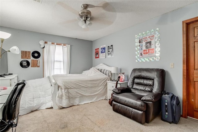 bedroom featuring ceiling fan, a textured ceiling, and carpet