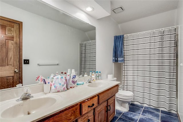 bathroom with tile patterned flooring, double vanity, toilet, and a sink