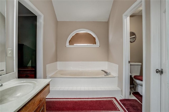 bathroom featuring a garden tub, vanity, and toilet