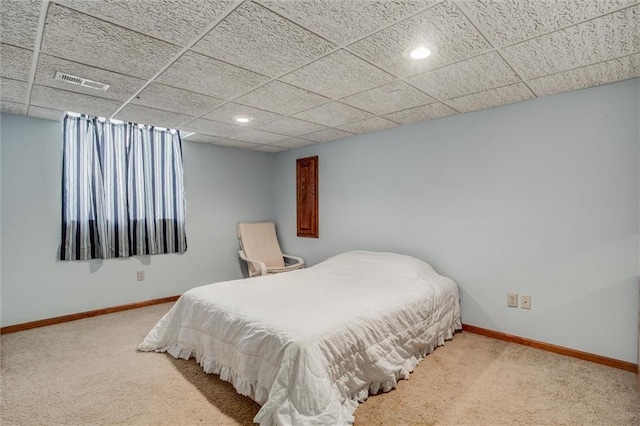 bedroom with visible vents, carpet flooring, baseboards, and a drop ceiling