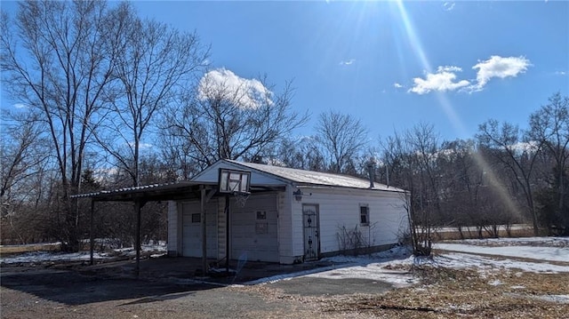 snow covered property with a detached garage and an outdoor structure