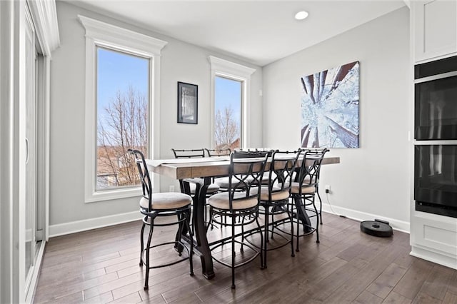 dining space featuring a healthy amount of sunlight, baseboards, and dark wood finished floors