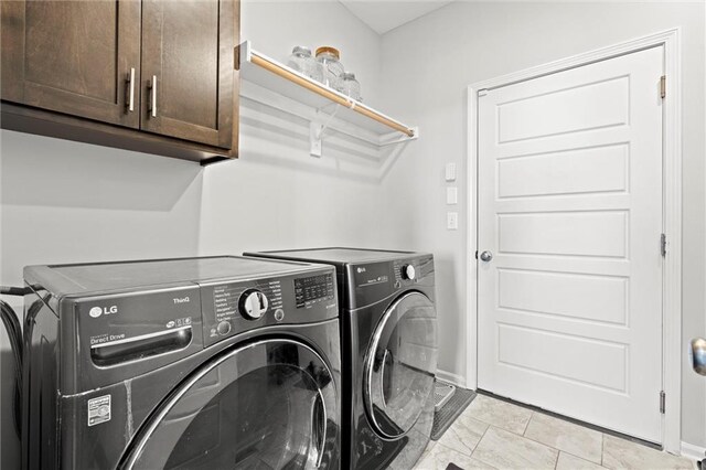 laundry room featuring cabinet space, baseboards, and independent washer and dryer