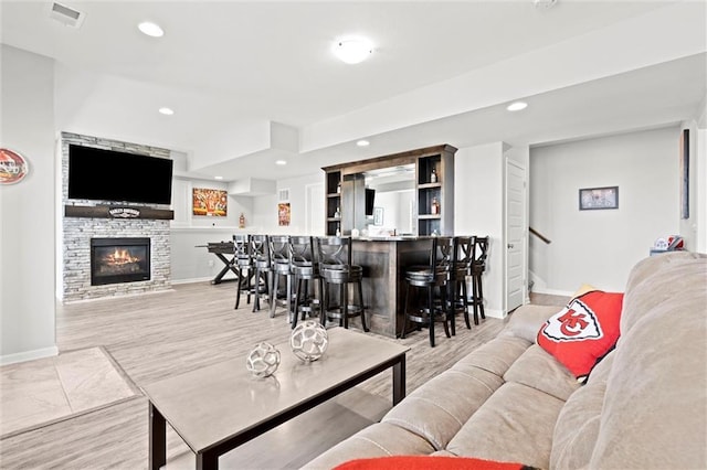 living room with baseboards, wet bar, visible vents, and recessed lighting