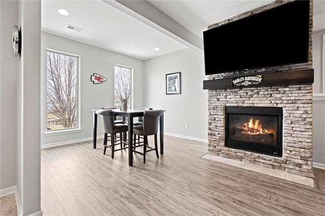 dining area with visible vents, baseboards, wood finished floors, a fireplace, and recessed lighting