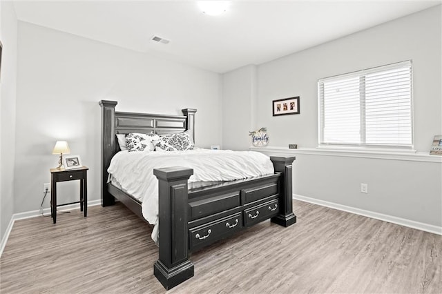 bedroom featuring baseboards, visible vents, and light wood-style floors