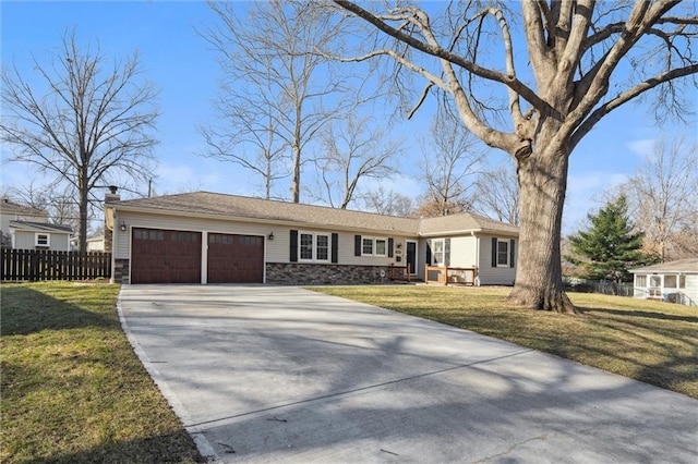 ranch-style home with a front lawn, fence, a garage, and driveway