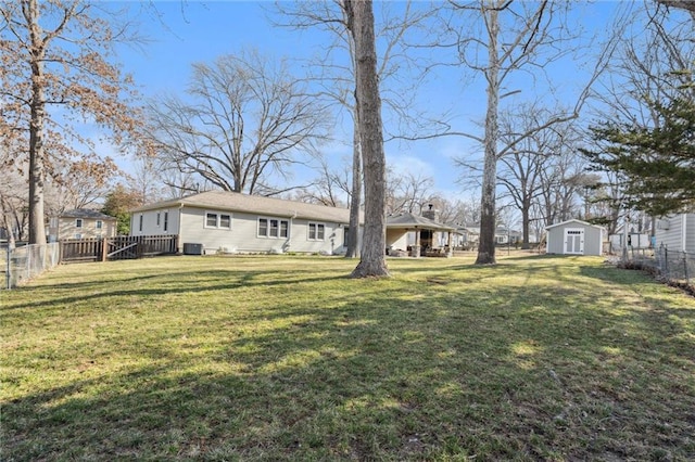 view of yard with a storage shed, an outdoor structure, central air condition unit, and a fenced backyard