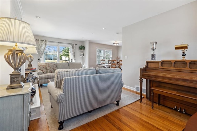 living room featuring visible vents, recessed lighting, baseboards, and wood finished floors