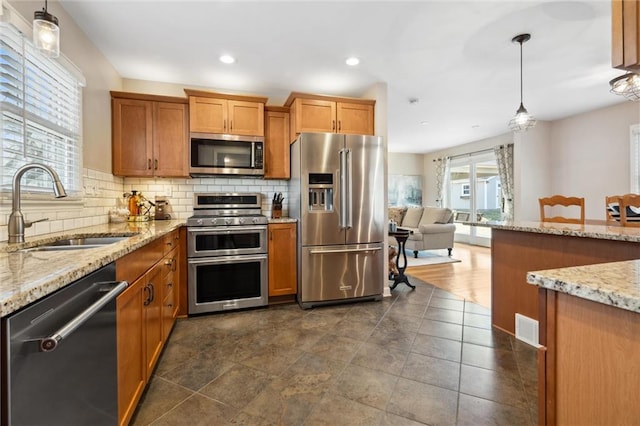 kitchen featuring a sink, stainless steel appliances, tasteful backsplash, and brown cabinetry