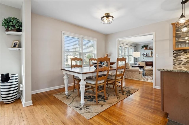 dining room with light wood-type flooring and baseboards