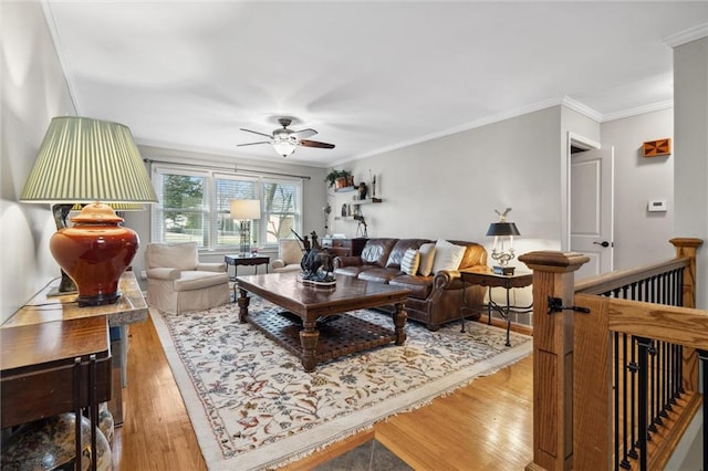 living room with ceiling fan, wood finished floors, and crown molding