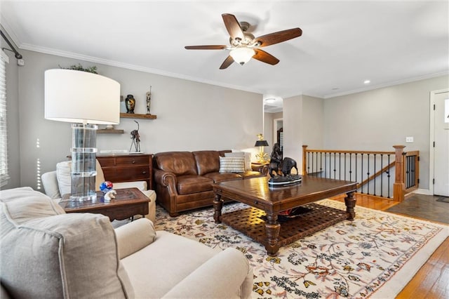 living room featuring ceiling fan, baseboards, wood finished floors, and crown molding