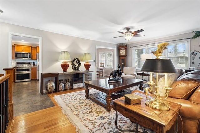 living room with light tile patterned flooring, ceiling fan, and ornamental molding