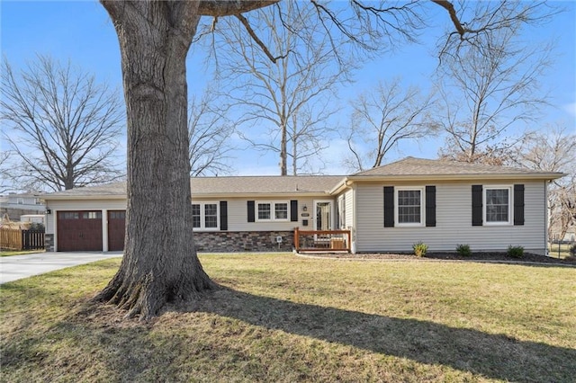 ranch-style house featuring concrete driveway, an attached garage, fence, and a front yard