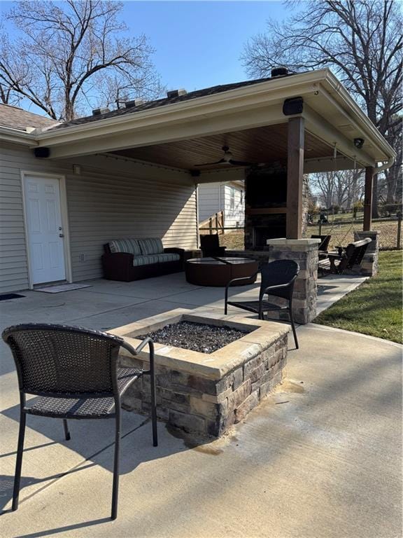 view of patio with an outdoor living space with a fire pit and ceiling fan