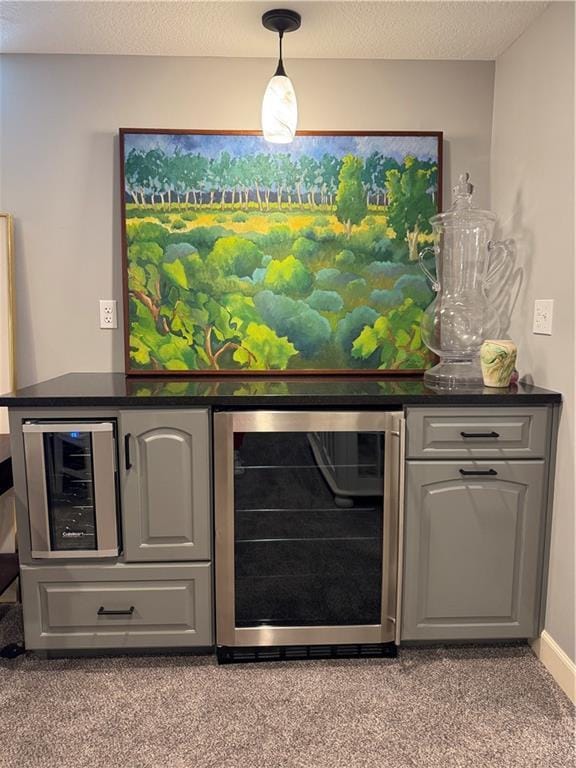 bar with a textured ceiling, beverage cooler, and a dry bar