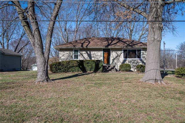 view of front of house featuring a storage unit, an outdoor structure, and a front yard