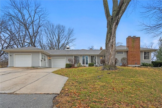 ranch-style house with a front yard, an attached garage, driveway, and a chimney