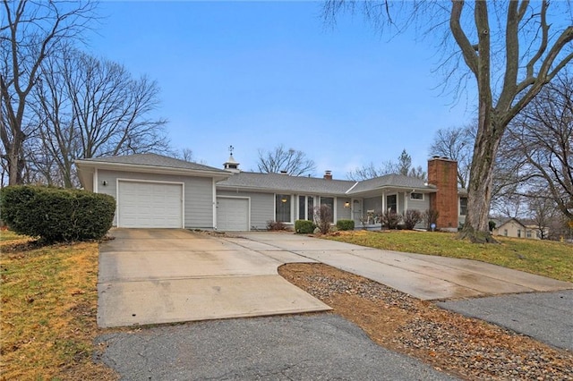 ranch-style home with a front yard, a garage, driveway, and a chimney