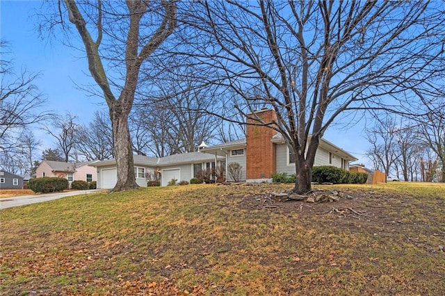 single story home with a front lawn, an attached garage, driveway, and a chimney