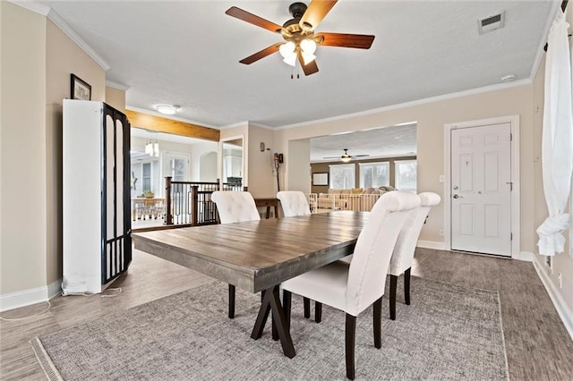 dining room with visible vents, crown molding, and a ceiling fan