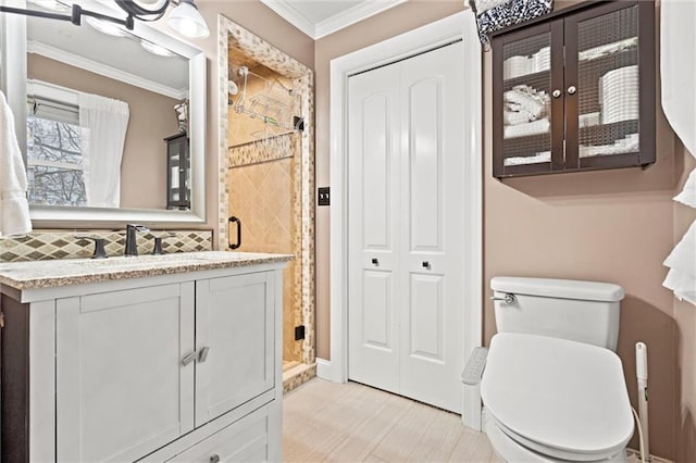 bathroom with toilet, ornamental molding, tasteful backsplash, a shower stall, and vanity