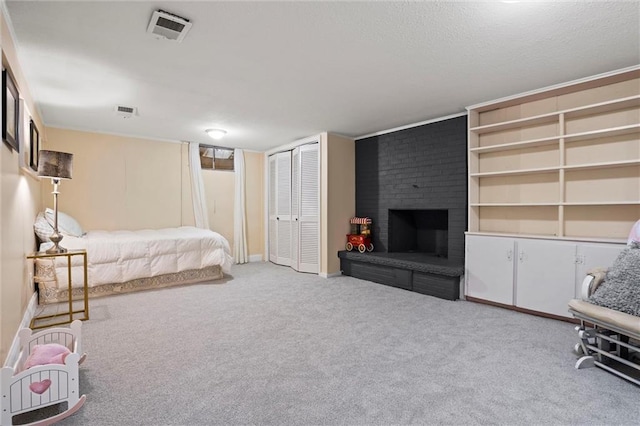 carpeted bedroom featuring visible vents, a fireplace, a textured ceiling, and baseboards