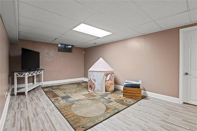 sitting room with a paneled ceiling, baseboards, and wood finished floors