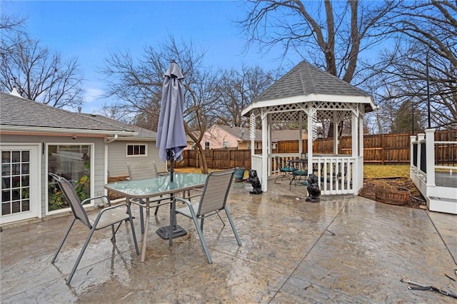 view of patio featuring a gazebo, outdoor dining area, and a fenced backyard