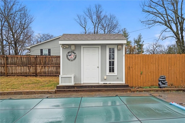 view of outbuilding with an outbuilding, entry steps, and a fenced backyard