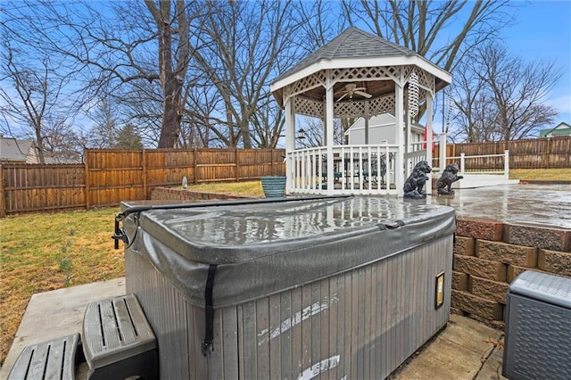 wooden deck featuring ceiling fan, a gazebo, a fenced backyard, and a hot tub